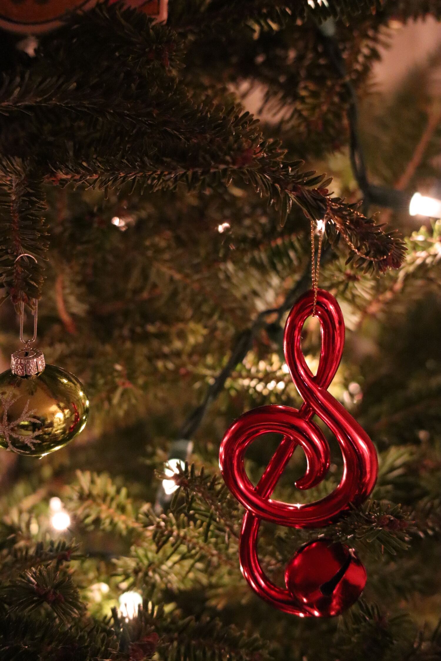 red treble clef Christmas ornament hanging on a tree